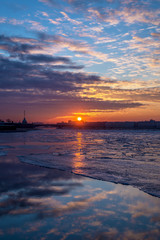 the orange - red sunrise over the Neva river with ice floes