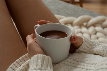 Female hands holding cup of cacao 