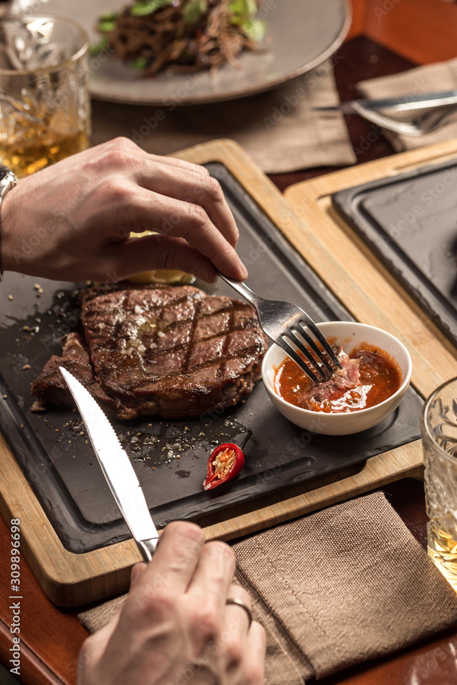 Wall mural man eating steak with mashed potato and tomato sauce at restaurant