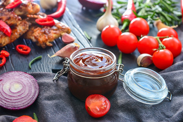 Jar with barbecue sauce on dark table
