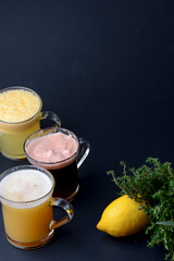 Selection of three different drinks with lemon on black background. Copy space, minimal style
