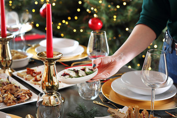 Herrings in oil, a gourmet snack on the holiday table. Christmas dishes, festive table setting. Horizontal composition.