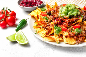 Plate with tasty chili con carne and nachos on table