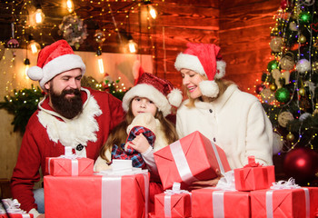Fototapeta na wymiar Christmas traditions concept. Christmas is the time to please. Joyful people. Gifts from Santa. Lovely daughter with parents. Father Santa claus costume with mom and little kid celebrating christmas