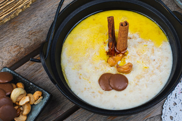 Traditional breakfast. Milk oatmeal with chocolate and granola. on a wooden table.