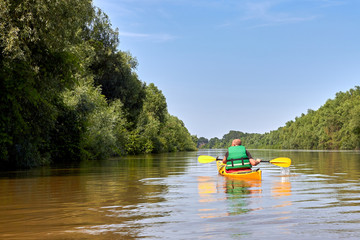 Fototapeta premium Tourist on yellow kayak kayaking on Danube river at summer