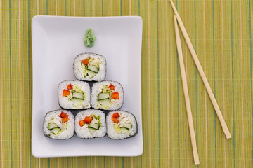 sushi rolls on a white plate as new year tree symbol