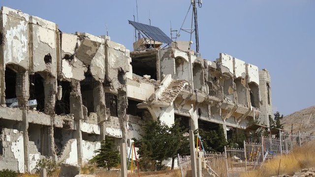 Static shot showing bombing damage to hotel due to Syrian war