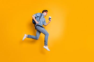 Full length body size view of nice attractive cheerful cheery guy jumping running season rest tour holding in hand tickets isolated over bright vivid shine vibrant yellow color background