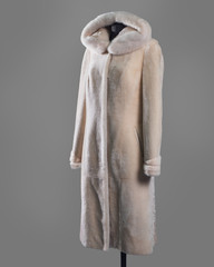Long white coat made of Mouton and trim on the edge of the hood and sleeves, oblique pockets with leather trim. Vertical frame
