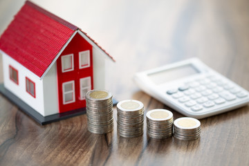 House and coins on table. Property investment and house mortgage financial concept,