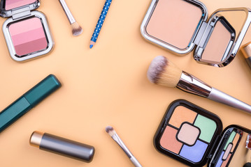 Flat view of cosmetics - lipstic, face-powder, brushes