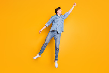 Full length body size photo of stylish trendy man being carried away with umbrella by gust of strong wind blowing isolated vivid color background