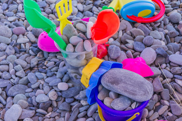 colorful children toys on pebble beach. Leisure and vacation concept