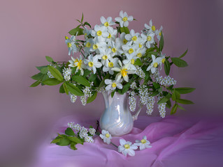 Spring flowers.A bouquet of yellow daffodils in a glass vase on a pink background.