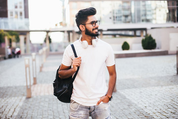 Indian handsome male student with bag in the street