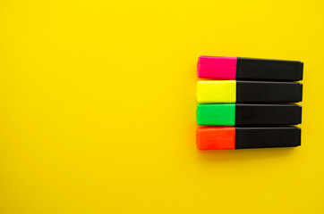 Colorful felt pens on the yellow background, top view. Bright template with highlighters flat lay. Border template. Creative frame with copy space. Education and business theme. Back to school.