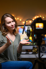 The video is a blogger, leads a YouTube channel, emotionally talks to the camera with a professional light, and a studio microphone.