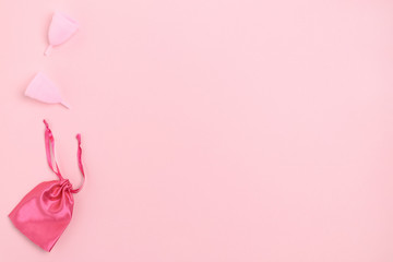 Menstrual cups with a bag on pink background with copy space