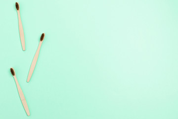 Frame made of bamboo toothbrushes on mint background