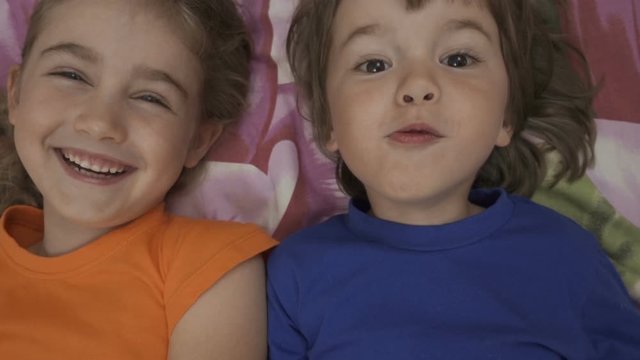 Happy Vlogger. Making Video Call. Friends Selfie. Excited Children Playing Lying on Bed and Taking Selfie. Little Brother and Sister Monkeying on Looking Camera.Taking Selfie Smartphone. Close up.