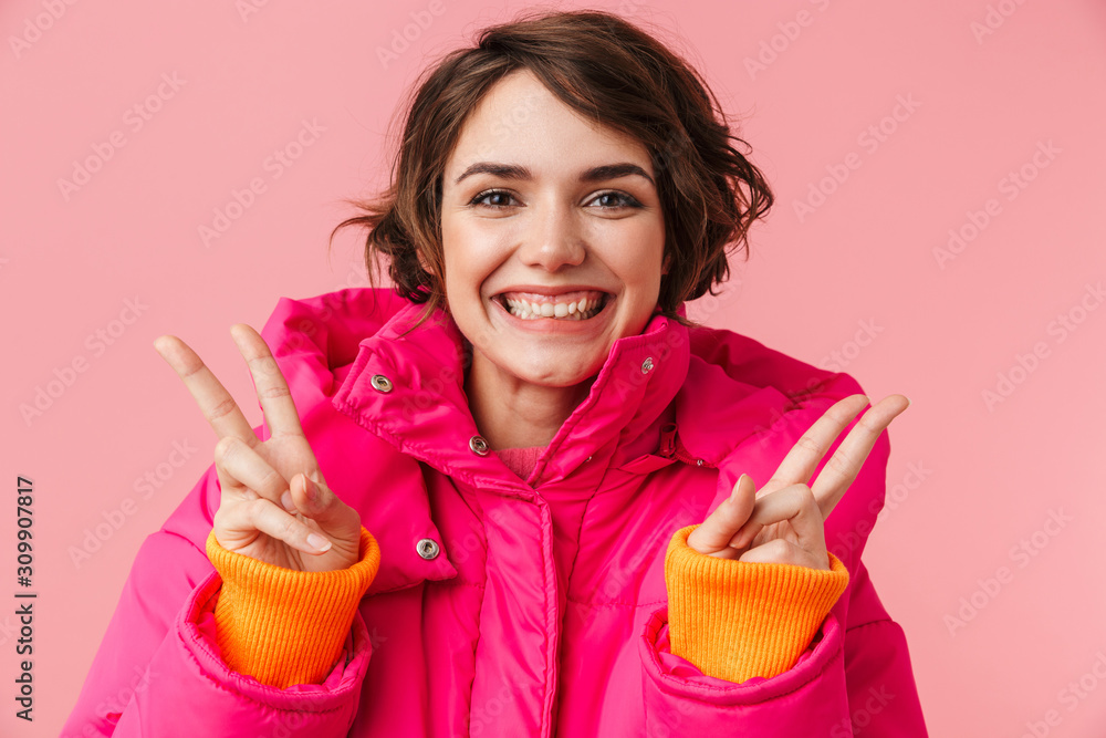 Poster Portrait of young happy woman gesturing peace sign and smiling