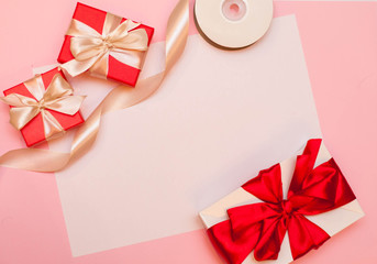 Christmas composition. Christmas gift, caramel, pine cones, on pink background. Flat lay, top view, copy space