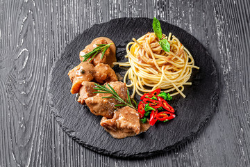 Italian food concept. Spaghetti pasta with veal meat goulash and red hot pepper. background image....