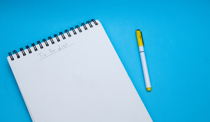 To-Do list, notebook and a pen, on a blue background