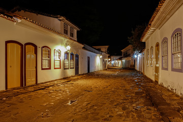 Fototapeta premium Atmospheric night view of illuminated street and buildings in historical center of Paraty, Brazil, Unesco World Heritage