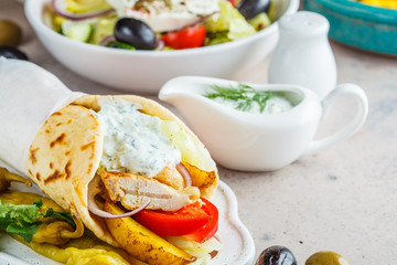 Chicken gyro pita with vegetables and tzatziki sauce..Traditional greek cuisine concept.
