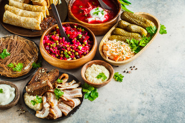 Traditional Russian cuisine concept. Borsch, jellied meat, lard, crepes, salad vinaigrette and...