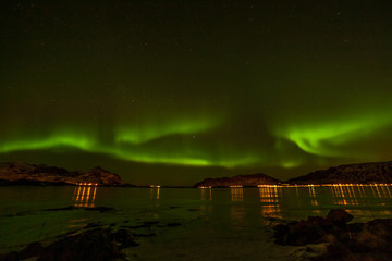 amazing aurora borealis, northern lights, over city in the North of Europe - Lofoten islands, Norway