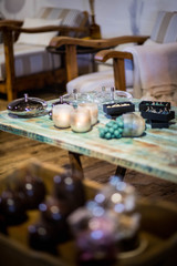 Bougies de plusieurs couleurs dans des boites noirs sur une table en chêne massif 