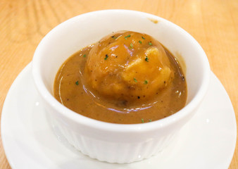 Mashed potatoes with gravy sauce in white bowl