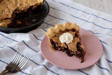 A piece of homemade Chocolate Walnut Derby Pie on a pink plate, дщц фтпду view. Close-up.
