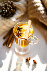 Hot winter drink with cinnamon and lemon on bright sunny day