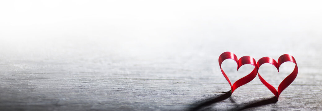 Red ribbon hearts on wood