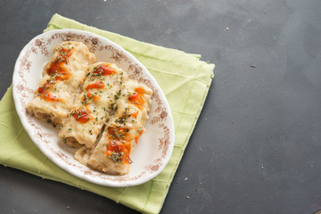 meat filled pasta on a plate. Italian cannelloni, Spanish canelones with green napkin