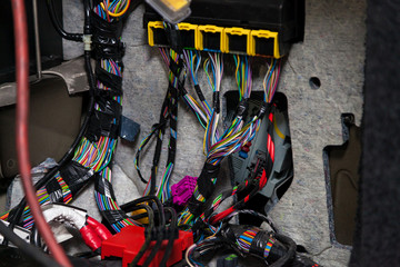 Large wide cable with multicolored red and green wires and connectors and terminals in the wiring repair shop and electricians for connecting and transmitting electricity and digital signals.