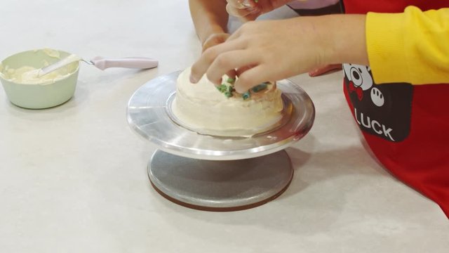 Icing a cake with whipped cream and a spatula