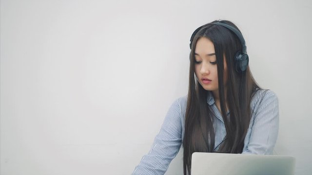 Cute asian girl sitting on the floor, preparing for exam, then raising up a sheet of paper with word EXAM written on it, sighing heavily.