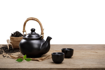 Obraz na płótnie Canvas Cup of hot tea with teapot, green tea leaves and dried herbs on the wooden table isolate white background with empty space, Organic product from the nature for healthy with traditional