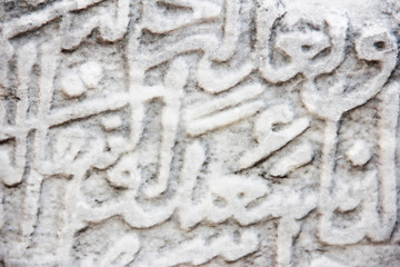 fragment of a gray stone wall depicting oriental patterns hieroglyphs