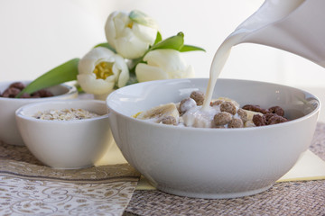 Morning breakfast. Chocolate balls with milk in a white bowl.