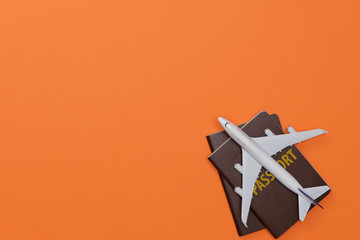 Creative flatlay of Traveler's accessories with passport and airplane toy isolated orange background with empty space,Tropical travel concept - Powered by Adobe