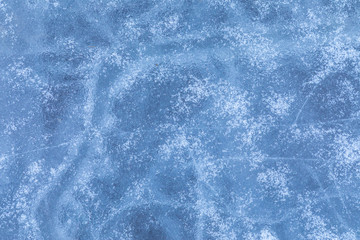 The macro or closeup shot of ice texture or background on the puddle or pool in the frost winter weather