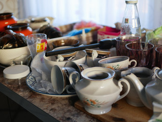 A lot of different dishes on the table. The mess on the table.