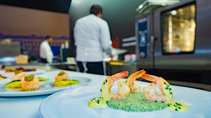 Shrimp dish. Shrimps on vegetable puree. Seafood platter in the restaurant kitchen. Serving shrimp dishes in a restaurant. Work as a cook. Table for ready meals in the restaurant kitchen.