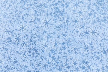 The macro or closeup shot of ice texture or background  with stars on the puddle or pool in the frost winter weather